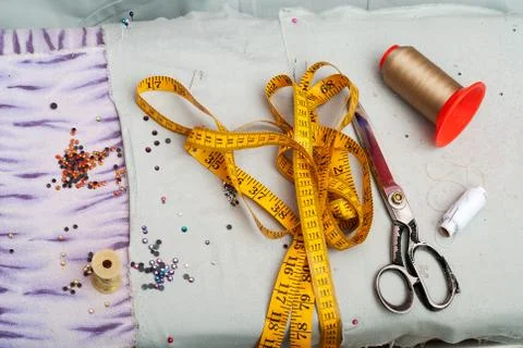 Scissors reel of thread, measuring tapes and natural fabric Foto stock
