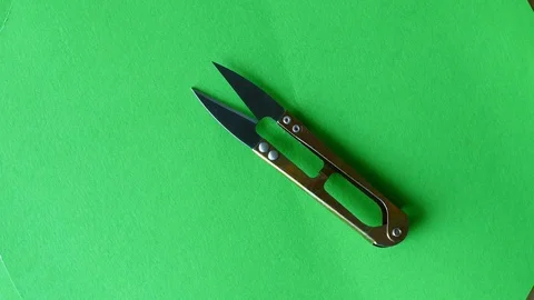 Scissors rotate on green ground. 스톡 동영상 95996370