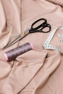 Scissors thread and centimeter on a fabric background Stock-Fotos