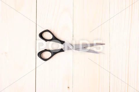 Scissors on wooden background Stock Photos