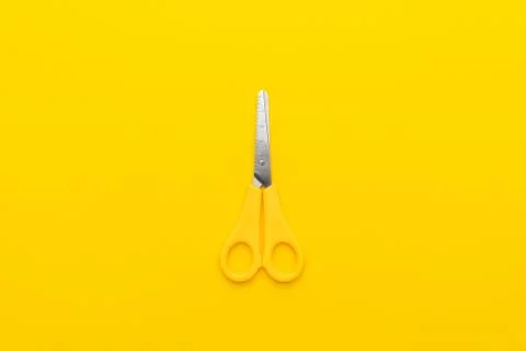 Scissors on yellow back Stock Photos