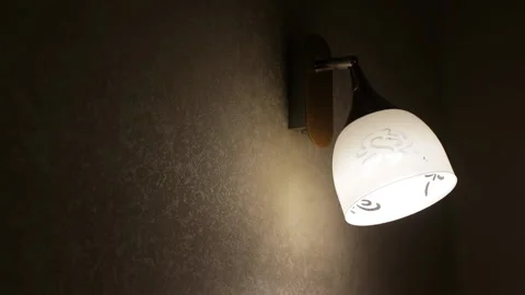 Sconce on the wall in dark room, turns on and off. Living room with wallpaper. Stock Footage 167459101