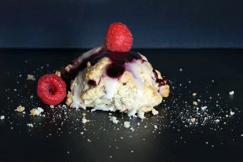 Scones with raspberry jam and lemon glaze on top Stock Photos