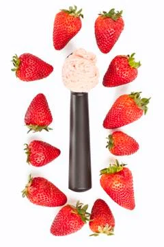 Scoop with ice cream surrounded with strawberries Stock Photos