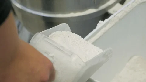 Scooper full of flour moves over to mixer dough kneads Stock Footage 93375939