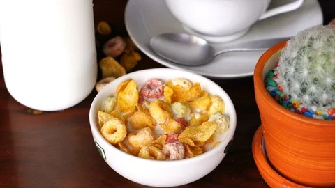 Scooping and eating cereal Corn Flakes and Froot Loops from a white bowl Stock Footage 102074417