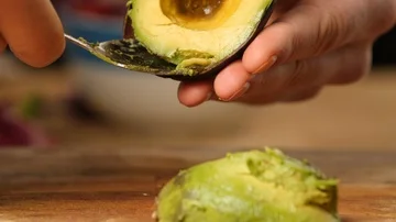 Scooping and preparing half an avocado with a spoon  Stock Footage 85702062