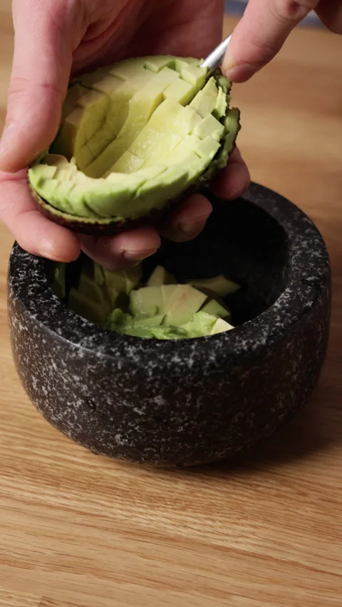 Scooping Avocado Flesh with Spoon Vertical Front View Stock Footage 336580041
