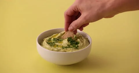 Scooping up avocado hummus with a chip 2 Stock Footage 132208106