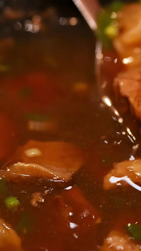 Scooping Braised Beef Chunks with Spoon from Hot Soup Видео 346267564