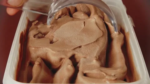 Scooping chocolate or cherry icecream from box Stock Footage 156881607