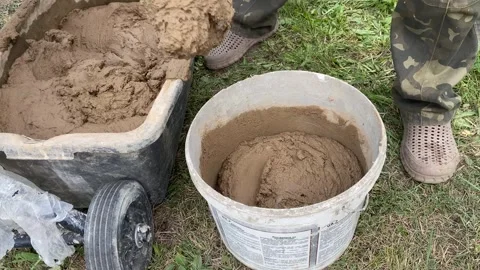 Scooping clay mixture into white bucket Stock Footage 316539520