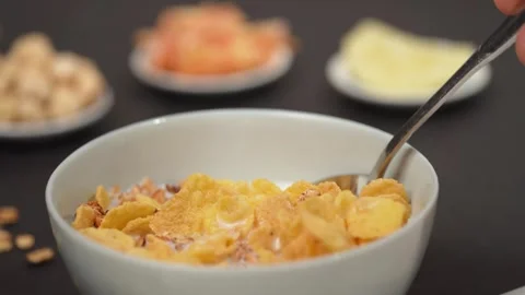 Scooping corn flakes and milk from a small bowl 库存影片 290112831