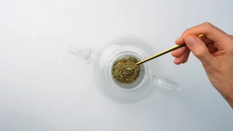 Scooping dried melissa leaves with gold spoon. Top view, hands holding yellow Stock Footage 342976345