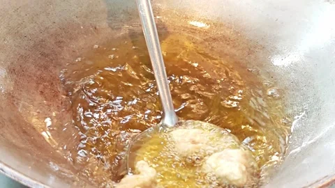 Scooping fried chicken nuggets from hot oil with a spatula. Stock Footage 342401426