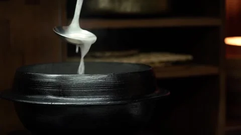 Scooping Hot Broth from Traditional Cauldron with Ladle Stock Footage 335736339