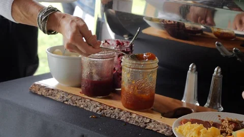 Scooping jam from jar and putting on plate Stock Footage 115732065