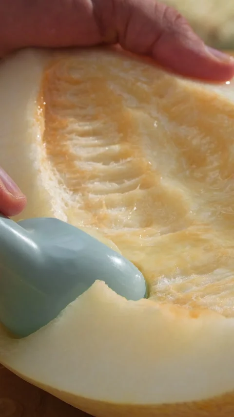 Scooping juicy fresh melon. Fresh summer fruits. Vertical slow motion Stock Footage 314017196
