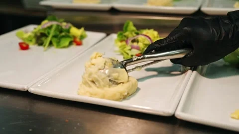 Scooping Mashed Potatoes Onto Plates in Commercial Kitchen Stock Footage 342219530