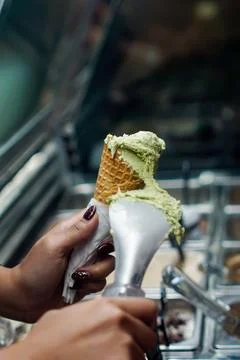 Scooping matcha ice cream onto cone close up shallow depth Stock Photos