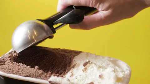 Scooping melted chocolate and vanilla ice cream out from container with modern Stock Footage 149691670