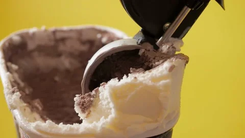 Scooping melted chocolate and vanilla ice cream out from container with modern Stock Footage 149691762