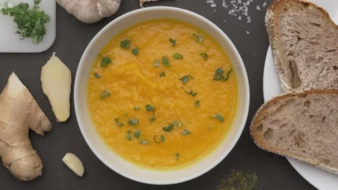 Scooping orange vegetables cream soup with a tablespoon 库存影片 290112909