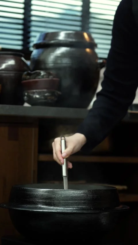 Scooping Ox Bone Broth from Large Cauldron with Ladle Stock Footage 335736333
