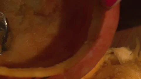 Scooping pumpkin flesh from inside with a spoon, hand with red nails Stock Footage