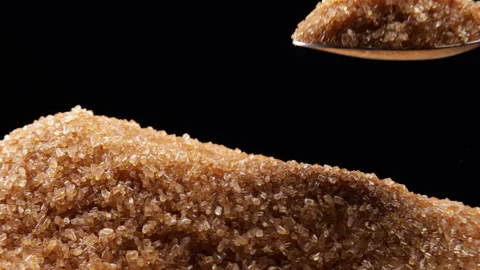 Scooping pure brown sugar from a mound of cane sugar with a spoon. Stock Footage 254103874