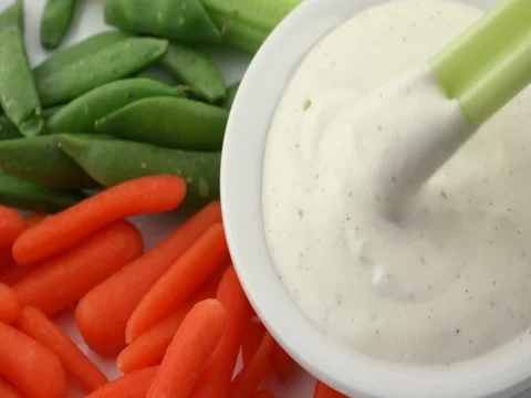 Scooping ranch dressing with a celery stalk. Stock Footage 74271096