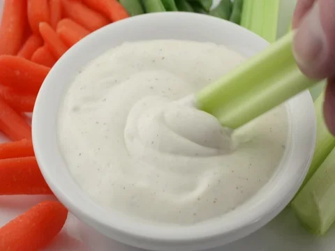 Scooping ranch dressing with a celery stalk. Stock Footage 74274058