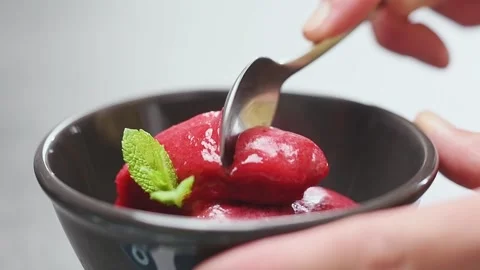 Scooping raspberry sorbet with a spoon. Stock Footage 154937097