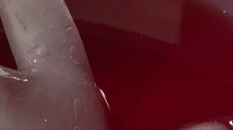 Scooping red drink with hand, closeup shot Stock Footage