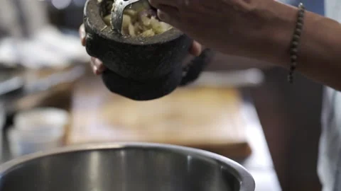 Scooping smashed ingredients from stone mortar  Stock Footage 145354893