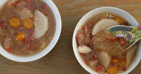 Scooping with a spoon soup made of snow fungus, fruits, and almonds. Stock Footage 283729948