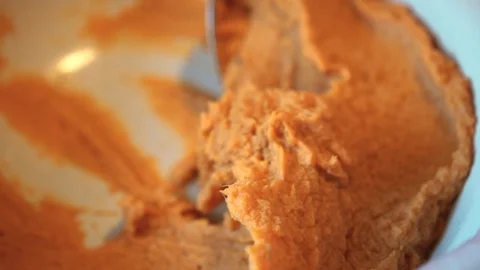 Scooping a spoonful of mashed sweet potatoes Video stock 93190042