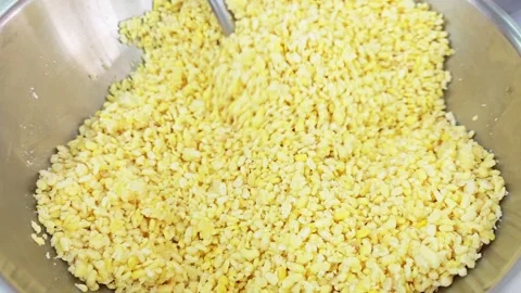 Scooping steamed yellow split mung beans with a metal ladle. 스톡 동영상 346533120