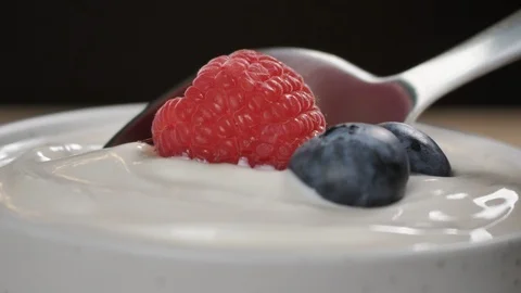 Scooping yogurt. Close up macro shot of yogurt with ripe fresh berries Stock Footage 124042392