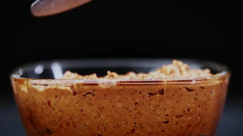 Scoops paprika paste from a glass container on a knife Stock Footage 208819808