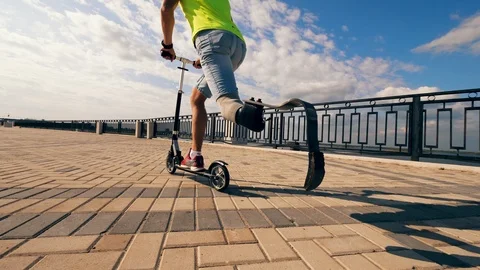 Scooter is being ridden by a person with a bionic leg Stock Footage 116802364