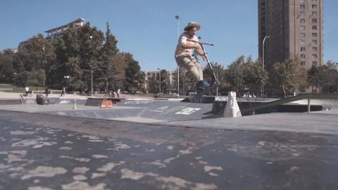 SCOOTER RIDER DOING A 360º BAR SPIN TRICK IN A SKATE PARK SLOW MOTION Stock Footage 102401543