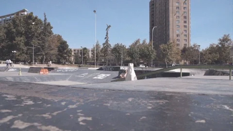SCOOTER RIDER DOING A SLIDING TRICK IN A SKATE PARK SLOW MOTION Video stock 102401526