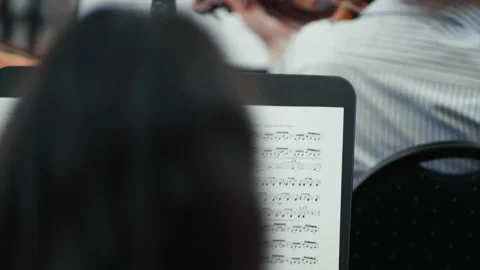 Score in the foreground and playing a violin turned on its back Stock Footage 142475227