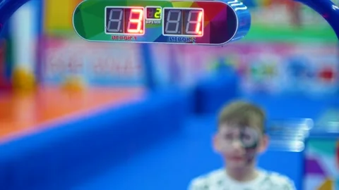 Score on the scoreboard when playing air hockey. A child plays in an amusement p Stock Footage