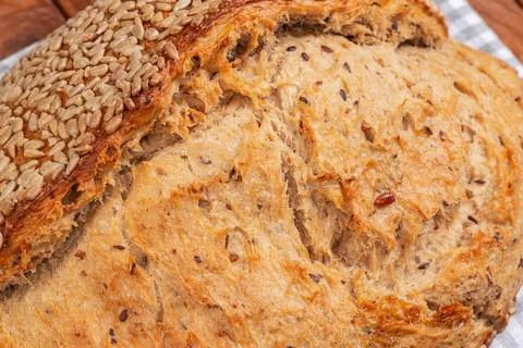 Scored artisan bread crust sprinkled with sunflower seeds close-up Stock Photos