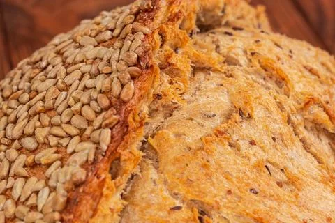Scored artisan bread crust sprinkled with sunflower seeds close-up Stock Photos