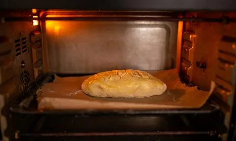 Scored bread loaf baking inside a hot oven Photos