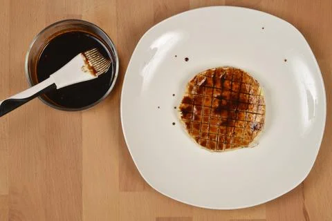 Scored Celeriac Root Slice with Sauce on White Plate Stock Photos