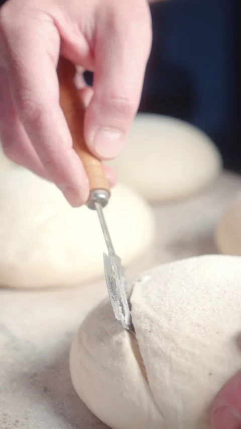 Scoring Bread Dough with a Blade to Create Decorative Patterns Stock Footage 344313453